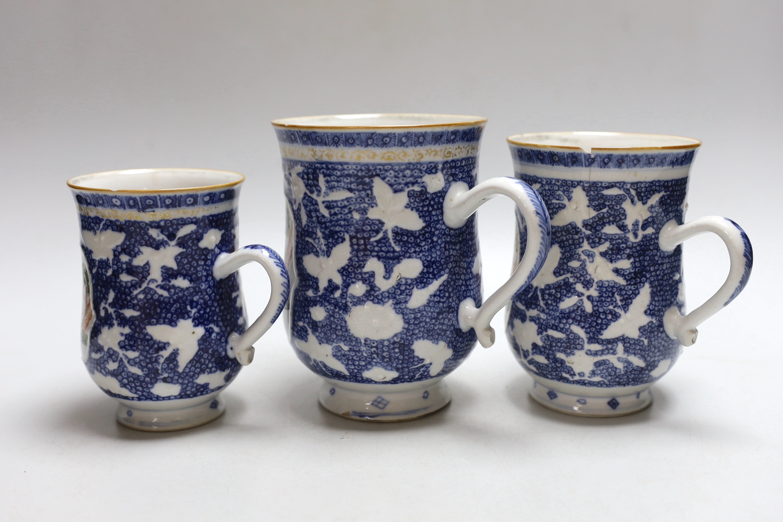 A graduated set of three Chinese mugs, Qianlong period, hand painted in the famille rose palette with figures, the largest 15cm high